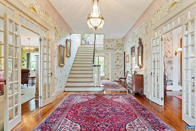 356 Routier Hill Rd, Hot Springs, VA 24445 - entrance foyer with french doors, wallpapered walls, a chandelier, wood finished floors, and stairs