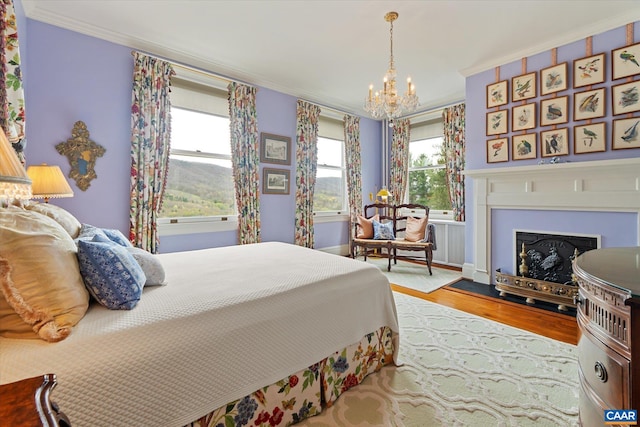 356 Routier Hill Rd, Hot Springs, VA 24445 - bedroom with wood finished floors, ornamental molding, a chandelier, and a fireplace with flush hearth