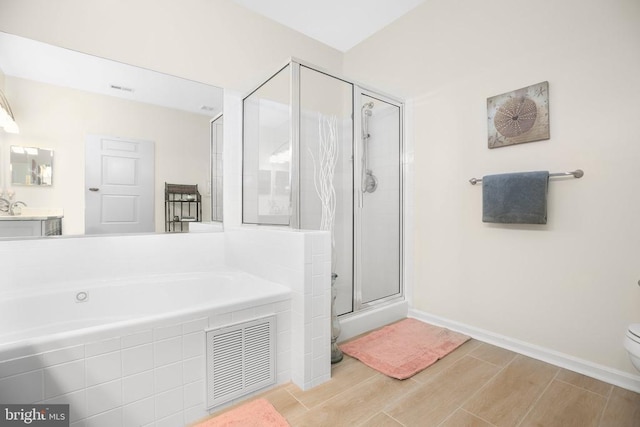 9204 Saint Andrews Ln, Fredericksburg, VA 22408 - bathroom featuring a bath, a shower stall, wood finished floors, and vanity