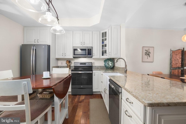 9204 Saint Andrews Ln, Fredericksburg, VA 22408 - kitchen with stainless steel appliances, a peninsula, dark wood-style flooring, white cabinets, and light stone countertops