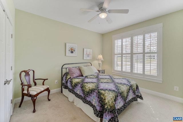 carpeted bedroom featuring baseboards and a ceiling fan
