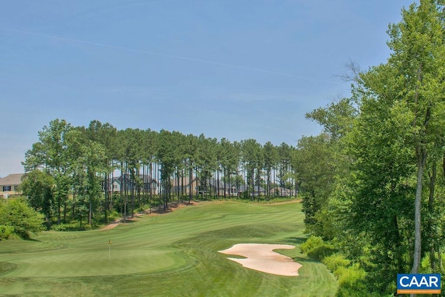 view of property's community with golf course view, an area to practice putting, and view of scattered trees