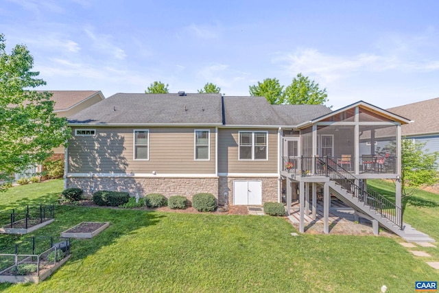 back of property featuring a sunroom, a vegetable garden, a yard, stairway, and a shingled roof