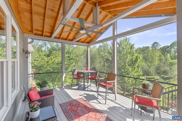 sunroom / solarium with outdoor dining space, lofted ceiling, a ceiling fan, and plenty of natural light