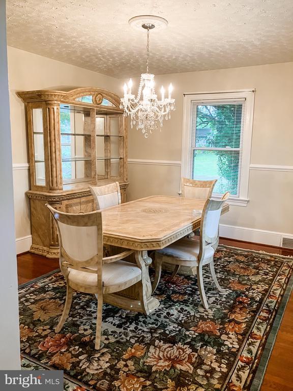 199 Peliso Ave, Orange, VA 22960 - dining room with a chandelier, a textured ceiling, wood finished floors, and baseboards