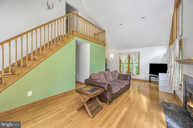 7312 Sugar Hollow Rd, Orange, VA 22960 - living room with high vaulted ceiling, hardwood / wood-style flooring, a fireplace with flush hearth, stairway, and baseboards