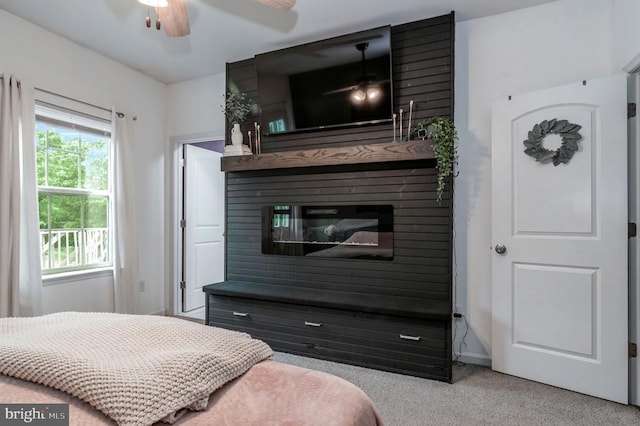  - bedroom with carpet floors, a glass covered fireplace, and a ceiling fan