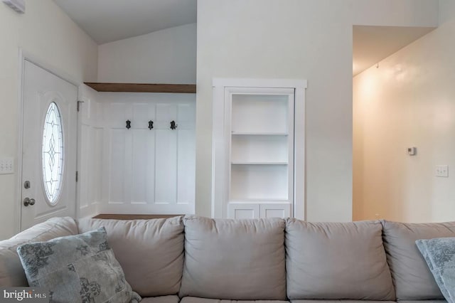  - living room featuring built in shelves and lofted ceiling