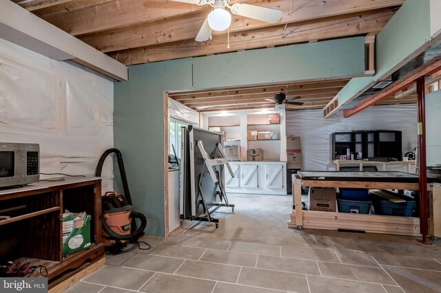  - basement with ceiling fan and tile patterned floors