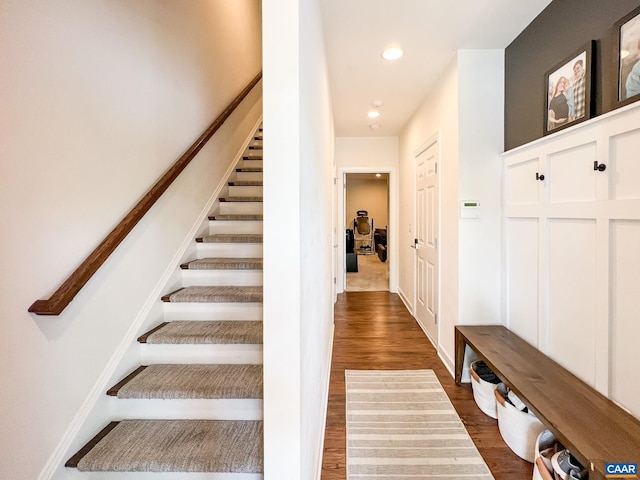 stairway featuring wood finished floors and recessed lighting