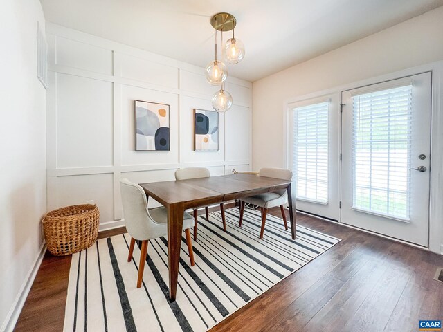 dining space with wood finished floors and a decorative wall