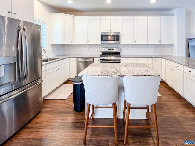 kitchen featuring appliances with stainless steel finishes, recessed lighting, a sink, backsplash, and white cabinetry