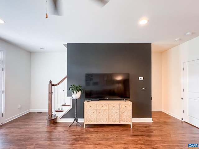 living area with stairway, wood finished floors, baseboards, recessed lighting, and ceiling fan