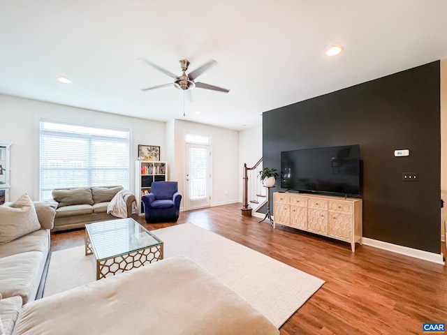 living area featuring stairs, ceiling fan, wood finished floors, baseboards, and recessed lighting