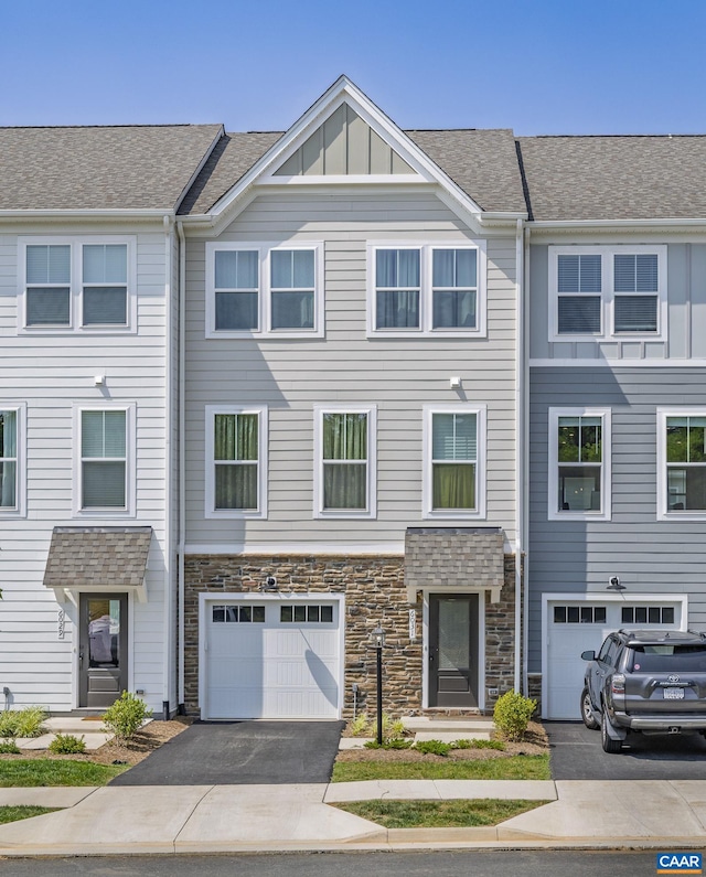 6031 Mccomb St, Crozet, VA 22932 - view of property featuring driveway, a garage, stone siding, board and batten siding, and roof with shingles
