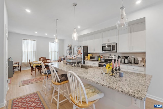 6031 Mccomb St, Crozet, VA 22932 - kitchen with appliances with stainless steel finishes, white cabinetry, decorative backsplash, recessed lighting, and light wood-style flooring