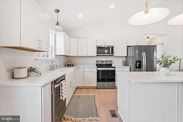 206 Seclusion Shores Dr, Mineral, VA 23117 - kitchen with appliances with stainless steel finishes, a sink, white cabinets, hanging light fixtures, and vaulted ceiling