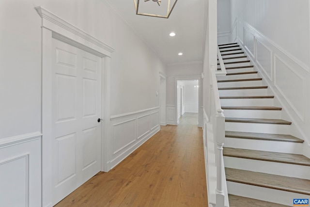 1108 E Jefferson St, Charlottesville, VA 22902 - stairway with a decorative wall, ornamental molding, wood finished floors, recessed lighting, and wainscoting