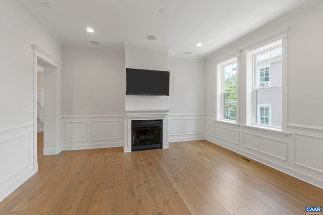 1108 E Jefferson St, Charlottesville, VA 22902 - unfurnished living room with a fireplace, light wood finished floors, crown molding, a decorative wall, and a wainscoted wall
