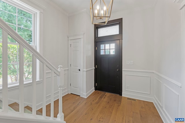 1108 E Jefferson St, Charlottesville, VA 22902 - entrance foyer with light wood finished floors, a chandelier, a wainscoted wall, a decorative wall, and stairs