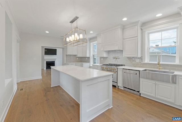 1108 E Jefferson St, Charlottesville, VA 22902 - kitchen featuring stainless steel appliances, backsplash, a kitchen island, white cabinets, and recessed lighting