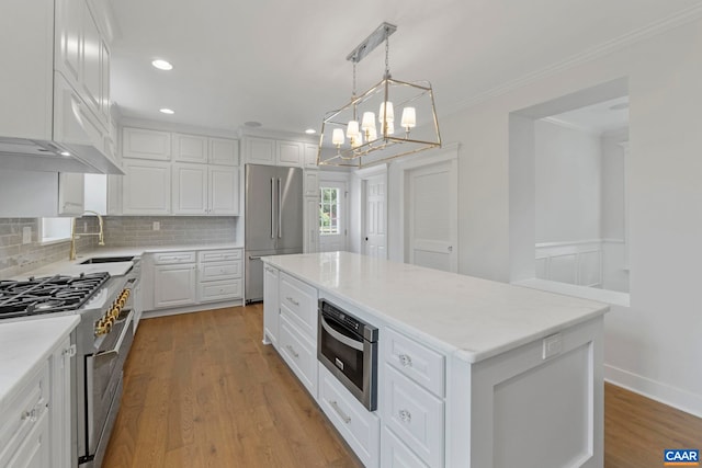 1108 E Jefferson St, Charlottesville, VA 22902 - kitchen with premium appliances, a chandelier, white cabinetry, decorative backsplash, and a center island