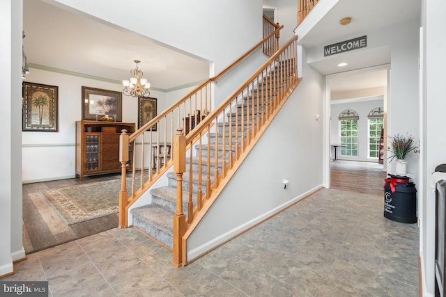  - stairs featuring a chandelier, stone finish flooring, and crown molding