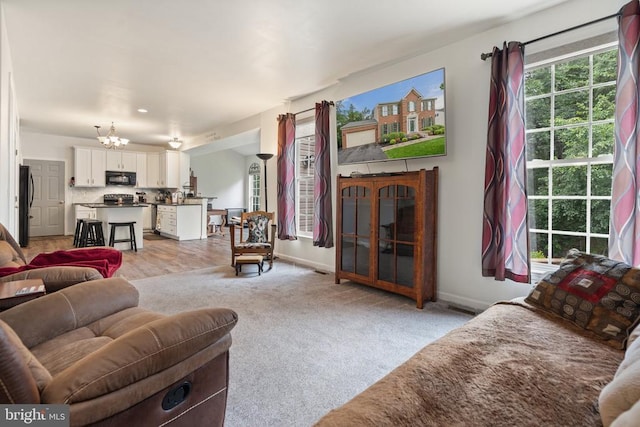  - living area featuring a chandelier and light colored carpet