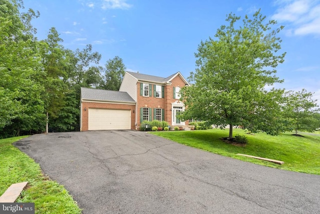 - view of front facade featuring brick siding, driveway, a garage, and a front lawn
