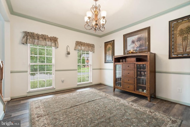  - doorway to outside featuring a chandelier, wood finished floors, and crown molding