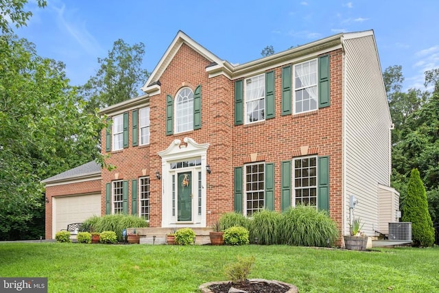  - colonial home with a front yard, brick siding, and a garage