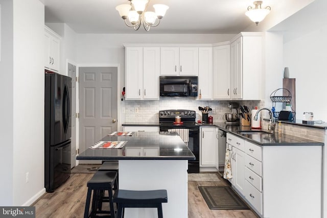  - kitchen with black appliances, dark countertops, backsplash, and white cabinets