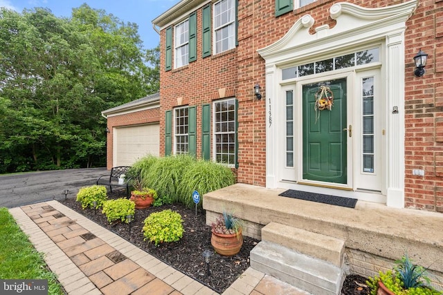  - view of exterior entry with brick siding and a garage
