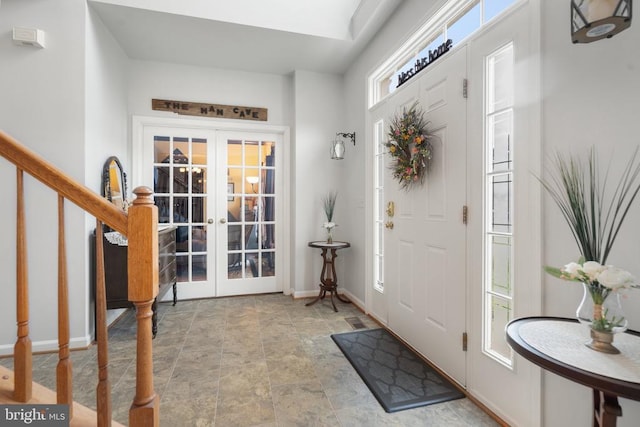  - foyer with french doors, stone finish flooring, and stairway