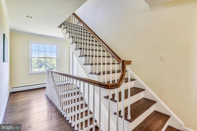  - stairway featuring baseboard heating, wood finished floors, and baseboards