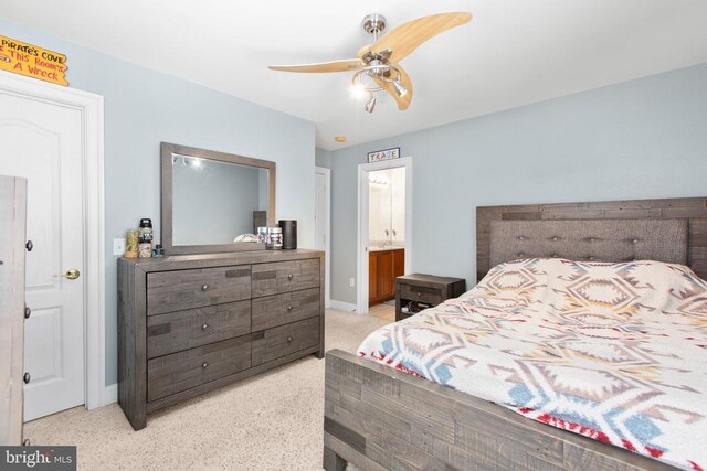 bedroom with baseboards, ensuite bath, and ceiling fan