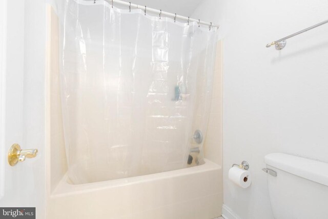 full bathroom featuring shower / bath combination with curtain and toilet