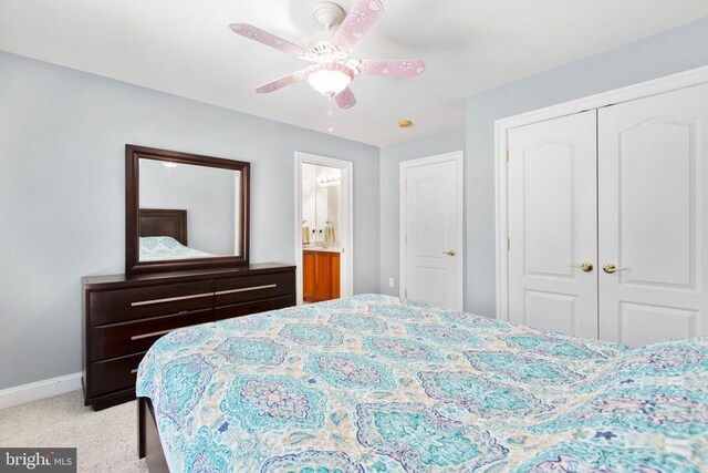 bedroom featuring a closet, baseboards, light colored carpet, and a ceiling fan