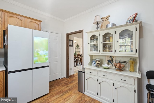 3704 Elk Creek Rd, Mineral, VA 23117 - kitchen featuring freestanding refrigerator, glass insert cabinets, crown molding, light countertops, and light wood-type flooring