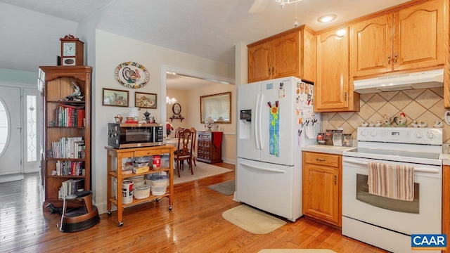 2273 Bloomer Springs Rd, Mcgaheysville, VA 22840 - kitchen with light wood-style flooring, white appliances, under cabinet range hood, light countertops, and tasteful backsplash