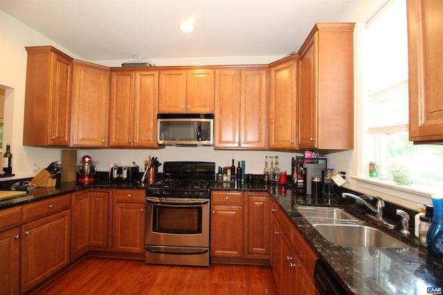 106 Melbourne Prk Cir Unit E, Charlottesville, VA 22901 - kitchen featuring appliances with stainless steel finishes, dark wood-type flooring, brown cabinets, dark stone counters, and recessed lighting