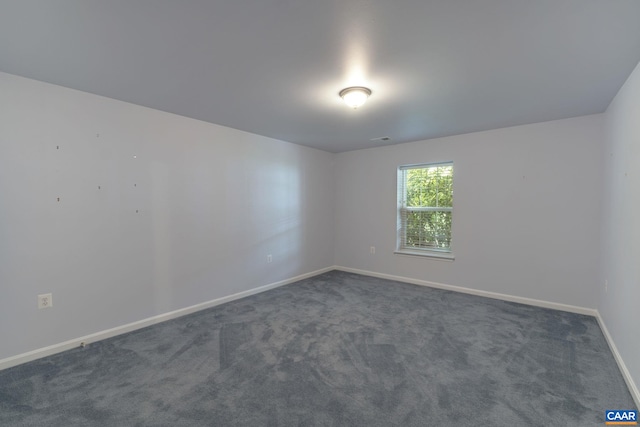 unfurnished room featuring dark colored carpet