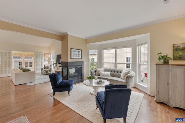 living room with crown molding, a multi sided fireplace, and light wood-type flooring