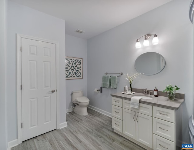 bathroom with vanity, hardwood / wood-style floors, and toilet