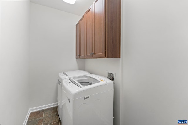 clothes washing area with cabinets and washer and dryer