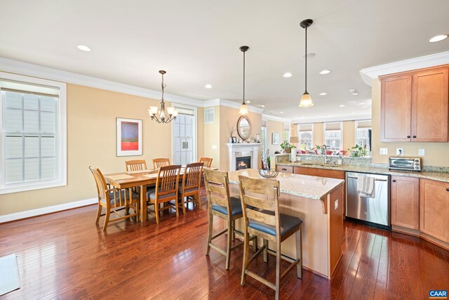 kitchen with dishwasher, dark wood-style floors, a peninsula, light stone countertops, and pendant lighting