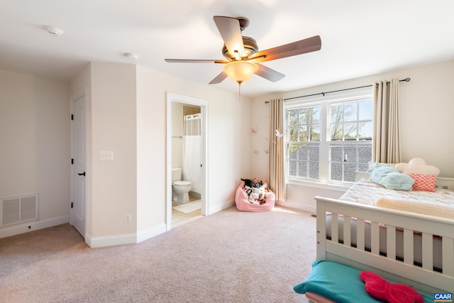 carpeted bedroom featuring baseboards, ensuite bath, and a ceiling fan