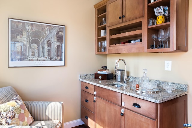 bar area featuring a sink and baseboards