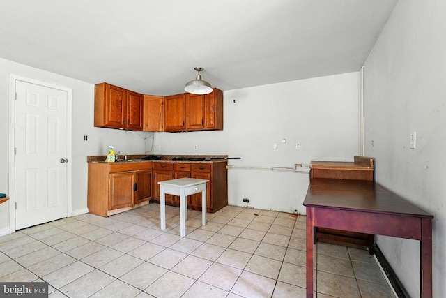  - kitchen with brown cabinetry, light tile patterned flooring, and a sink