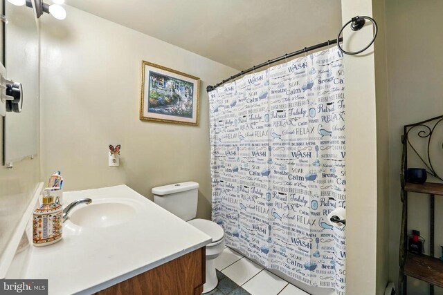  - full bath with toilet, vanity, tile patterned floors, and curtained shower